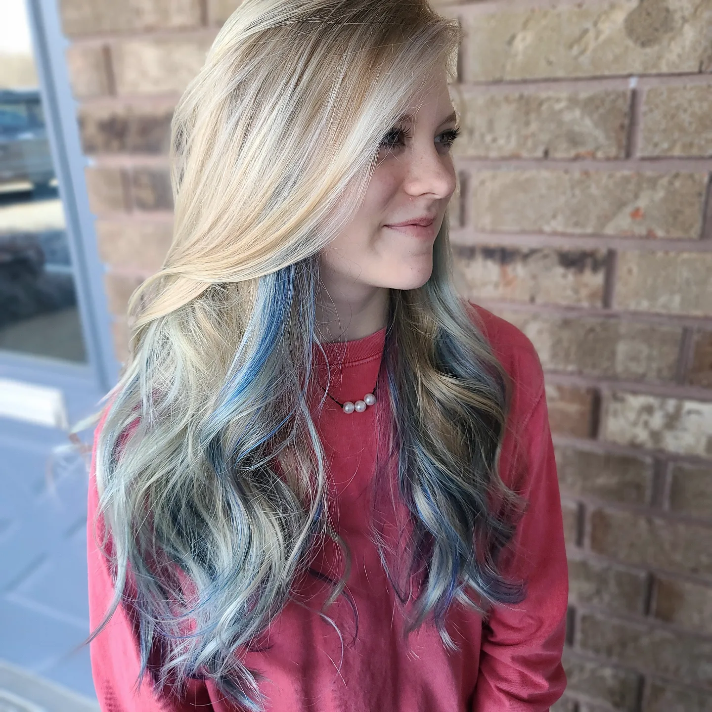 Blonde with blue peekaboo highlights and loose curls