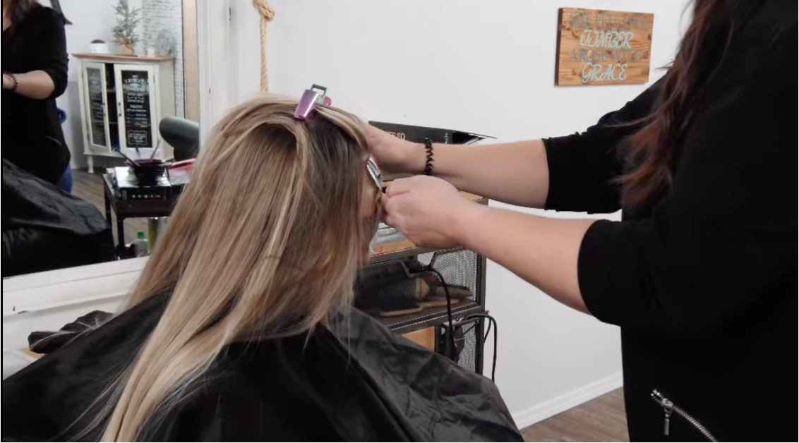 Layna styling a client's hair at Timber & Grace